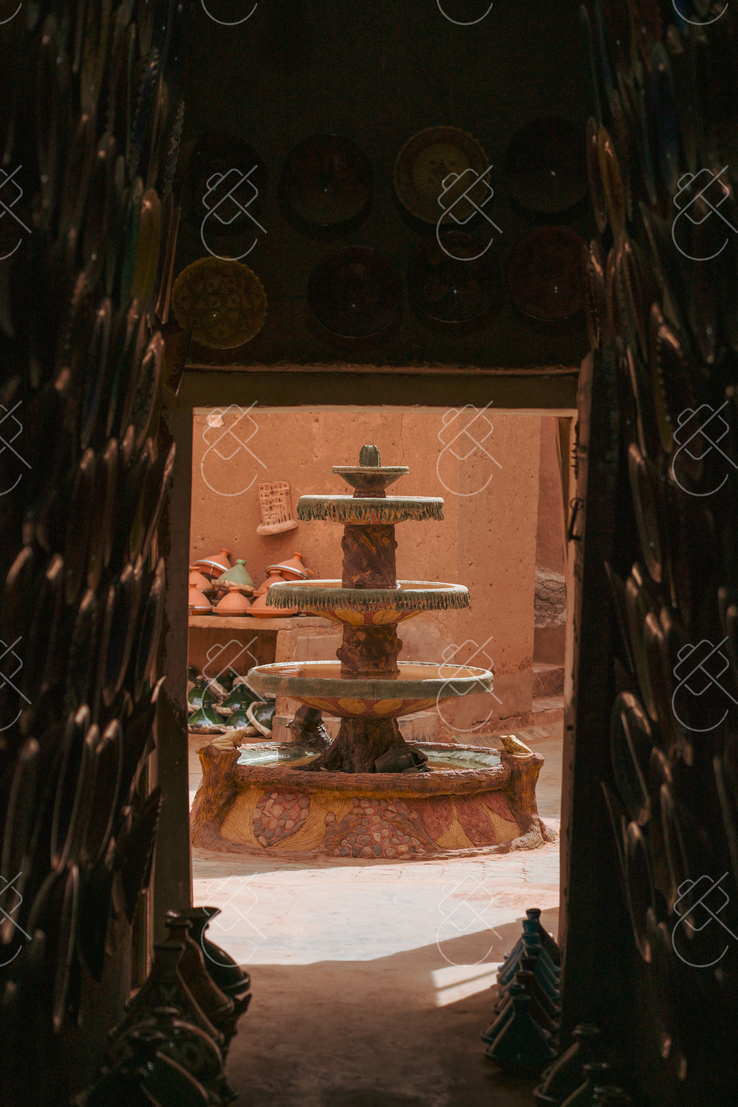 A tiled fountain glimpsed through a pottery workshop doorway — Tamgroute, fine art travel photography print available from Clever Tourists