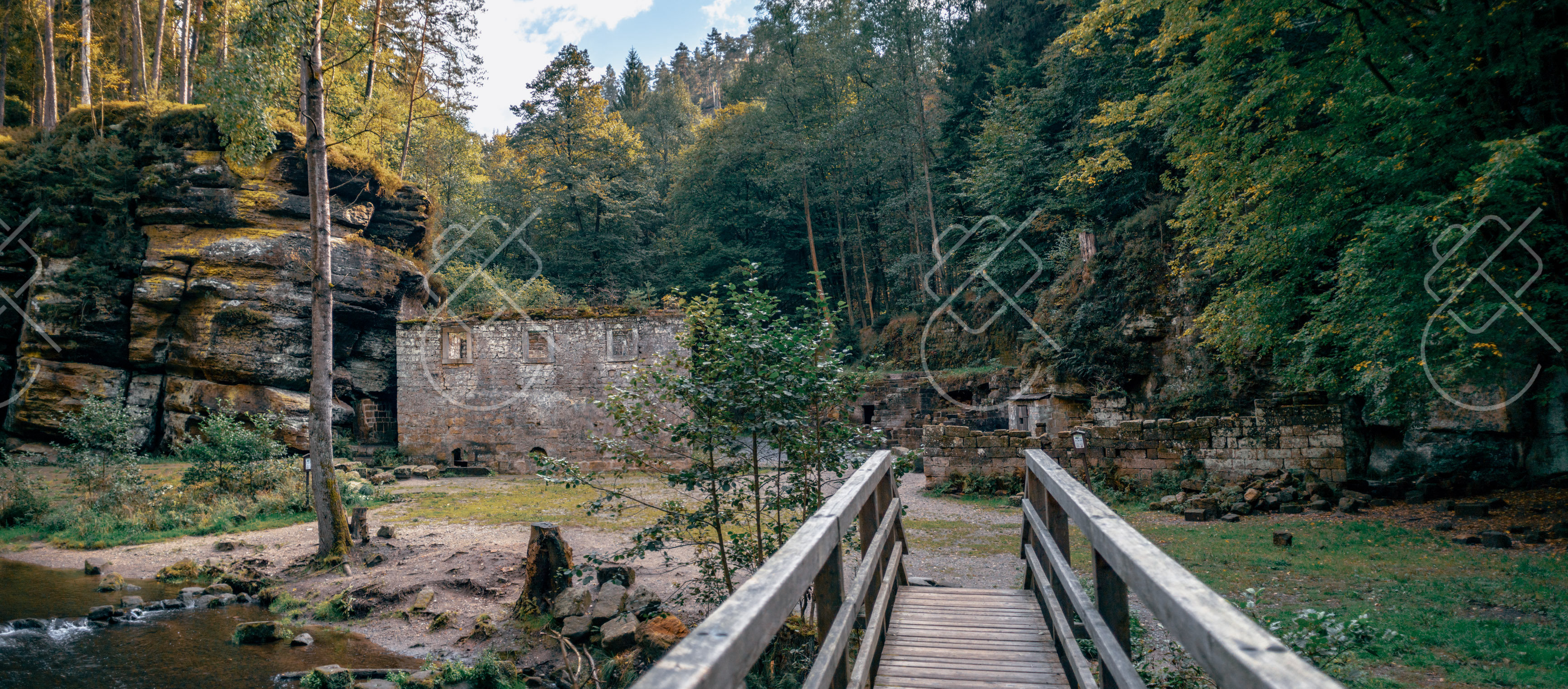 A wooden footbridge over the Kamenice near old mill ruins in the gorge — Hřensko, fine art travel photography print available from Clever Tourists