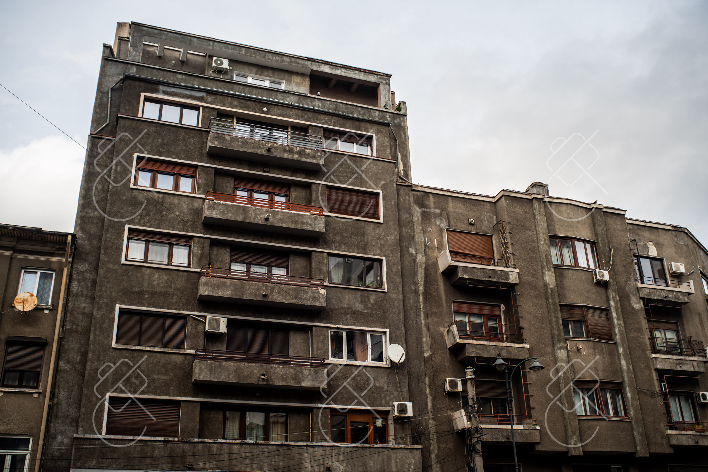 A weathered Communist-era apartment block with patched balconies in central Bucharest — Bucharest, fine art travel photography print available from Clever Tourists