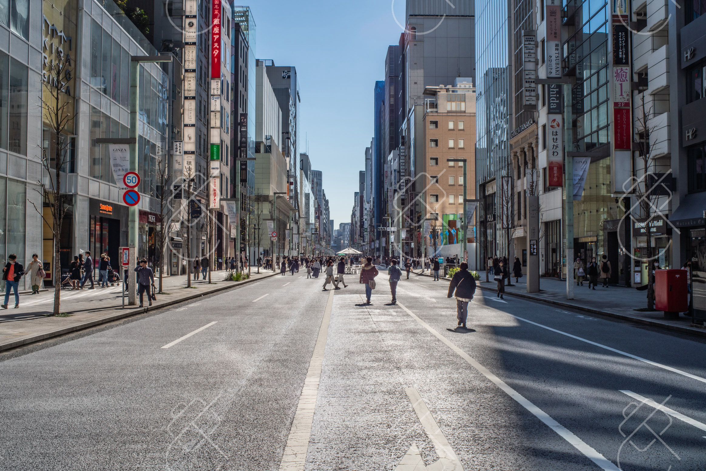 A broad avenue of glass storefronts and midday shoppers in central Tokyo — Tokyo, fine art travel photography print available from Clever Tourists