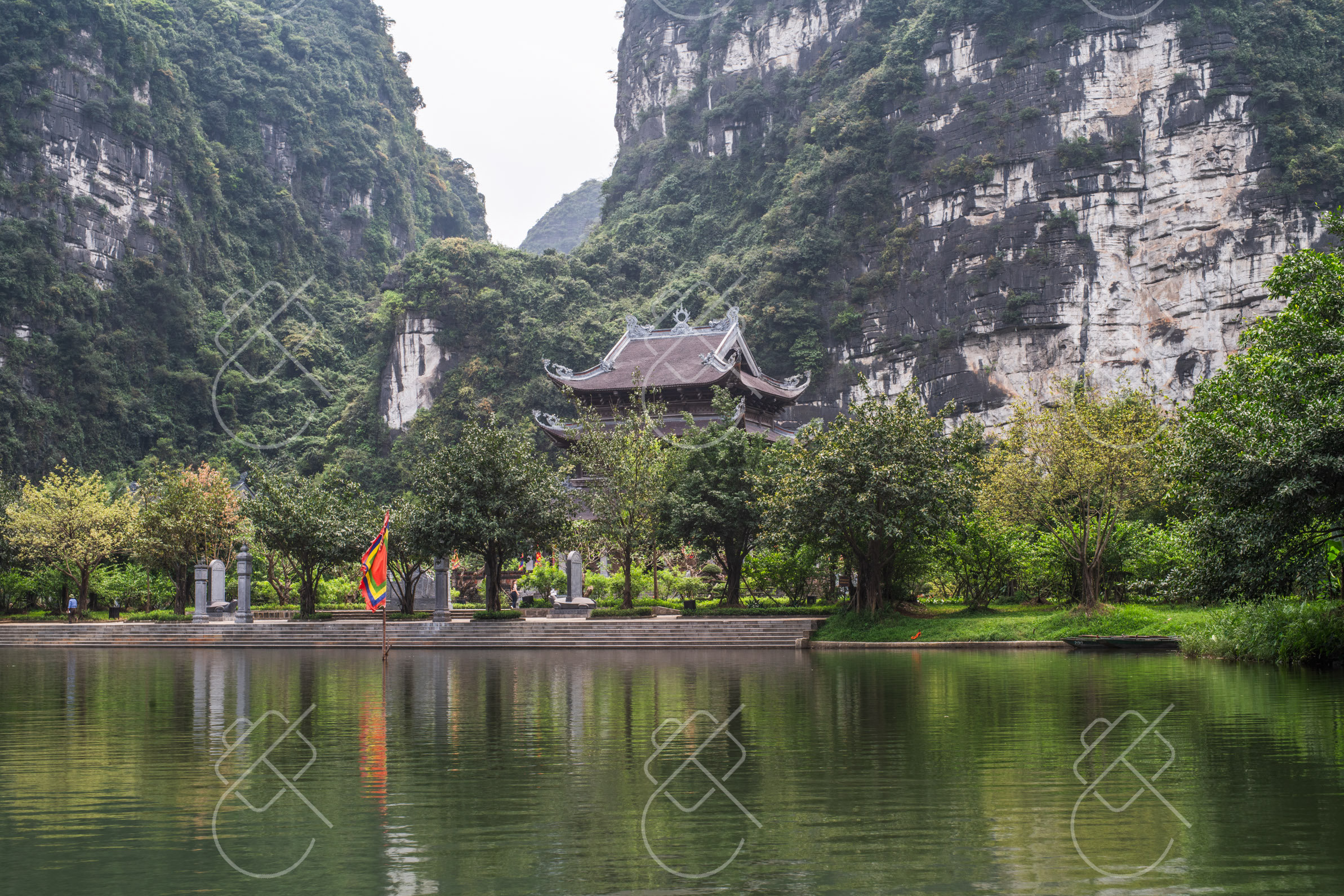 Temple architecture set directly against the limestone cliffs — Trang An & Hoa Lu