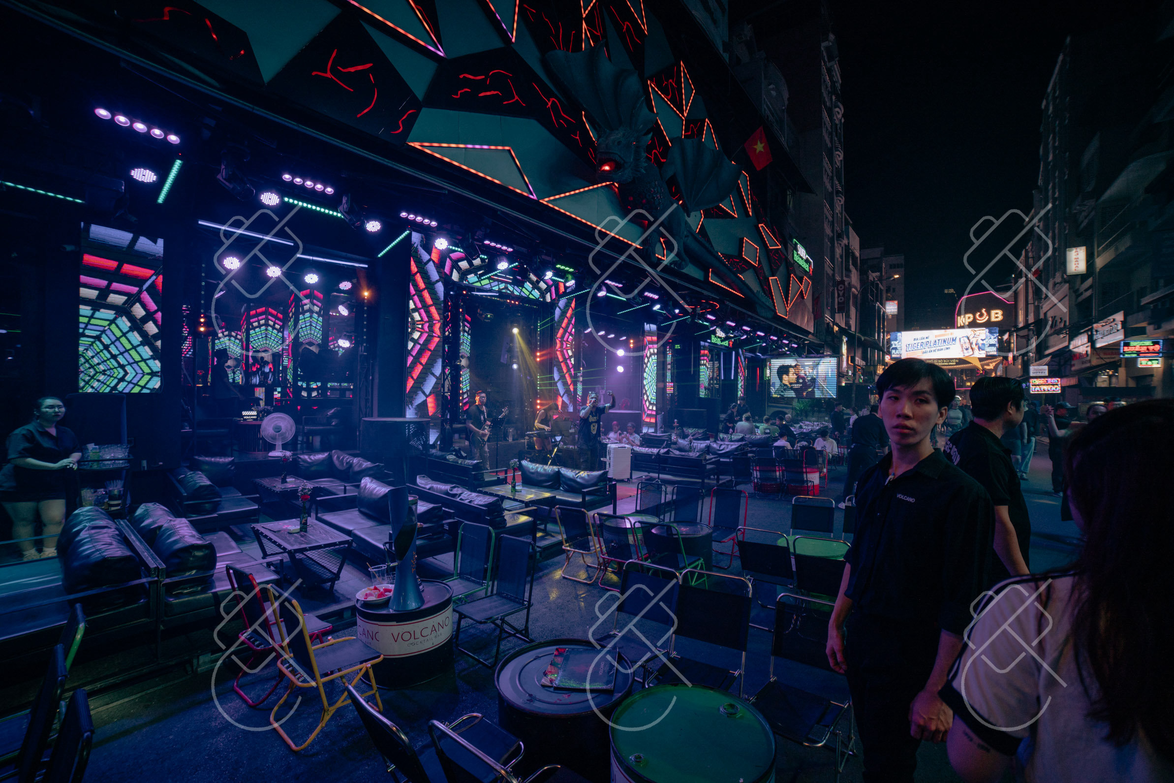 A neon-lit bar terrace spilling onto Bui Vien walking street after dark — Ho Chi Minh City, fine art travel photography print available from Clever Tourists