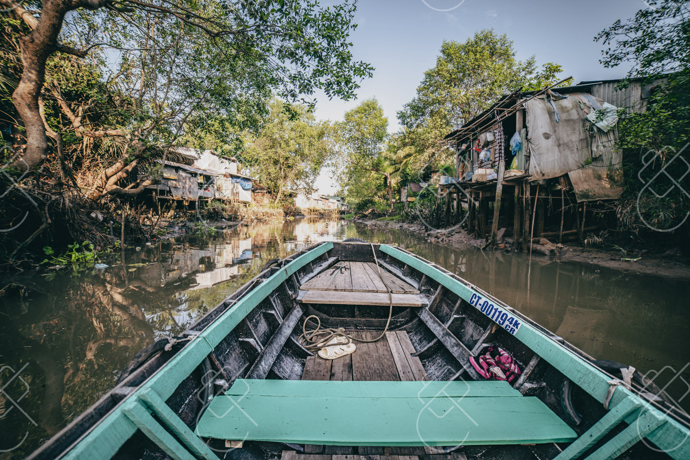 Small boats moored in a narrow canal beneath stilt houses — Can Tho, fine art travel photography print available from Clever Tourists