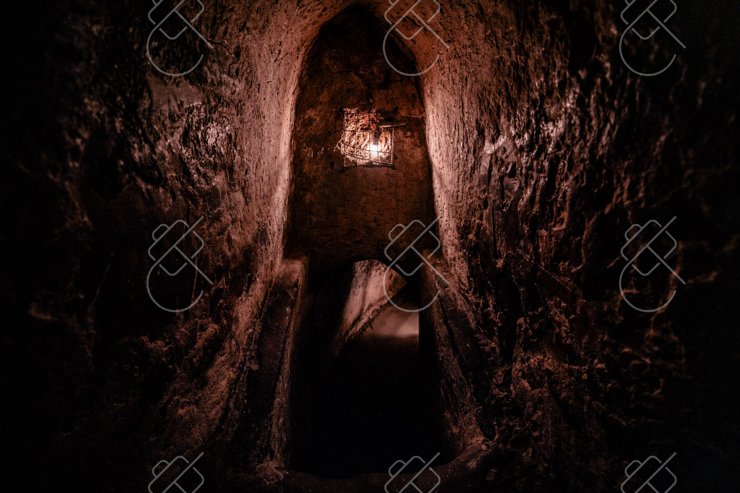 A narrow earthen passage at the Cu Chi Tunnels, lit by a single bulb — Ho Chi Minh City, fine art travel photography print available from Clever Tourists