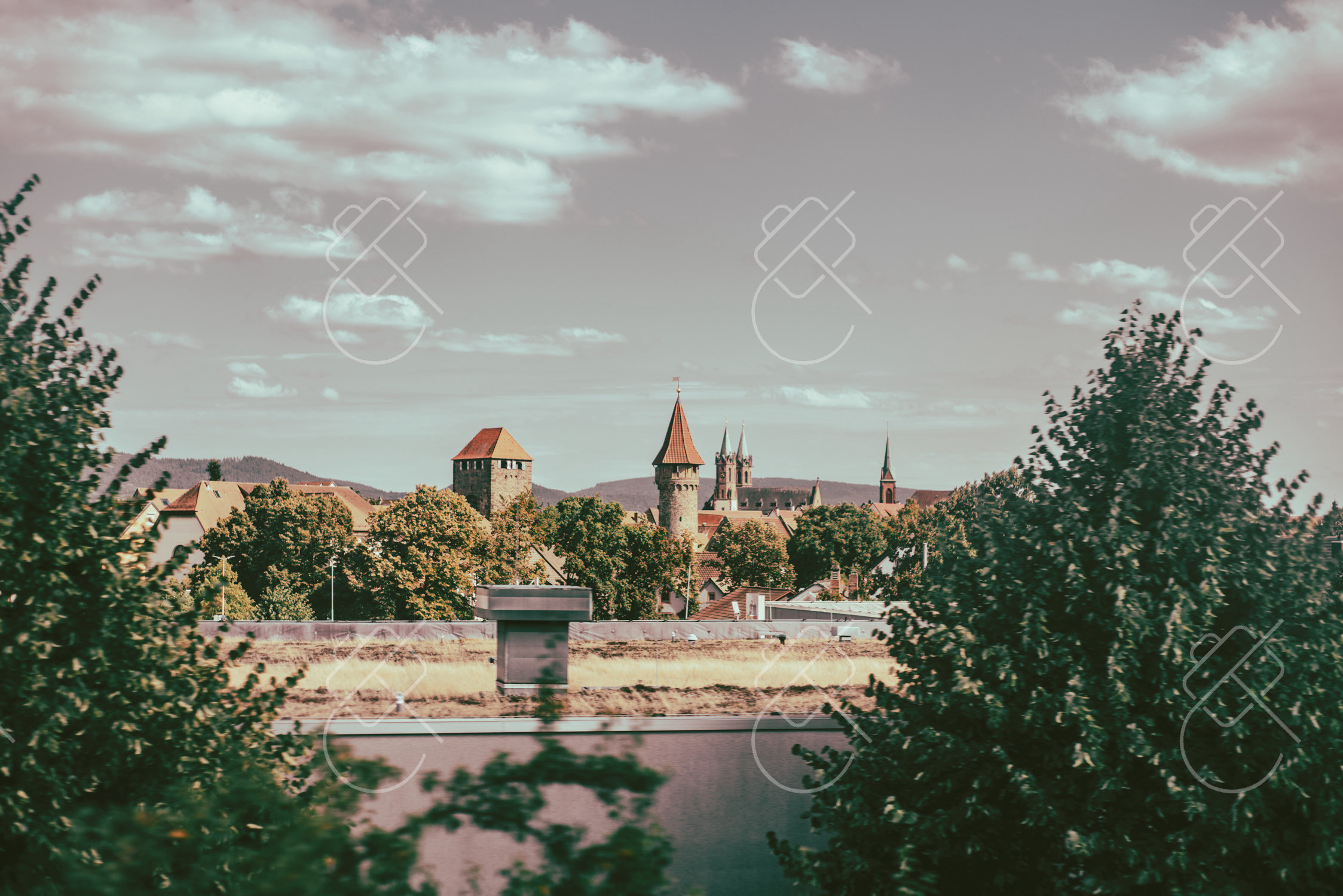 The Neckar and the Old Town's spires framed between trees along the riverbank — Heidelberg, fine art travel photography print available from Clever Tourists