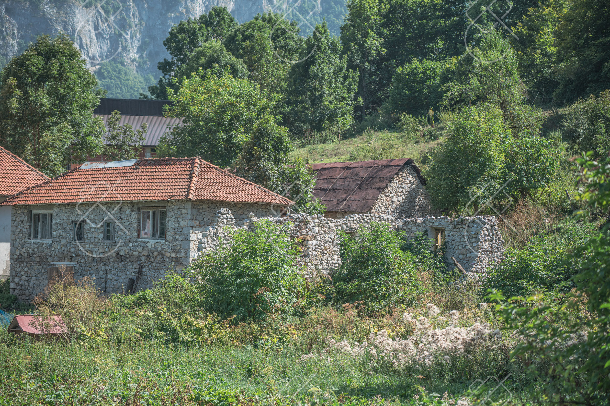 Limestone peaks of the Prokletije above a green valley floor — Gusinje
