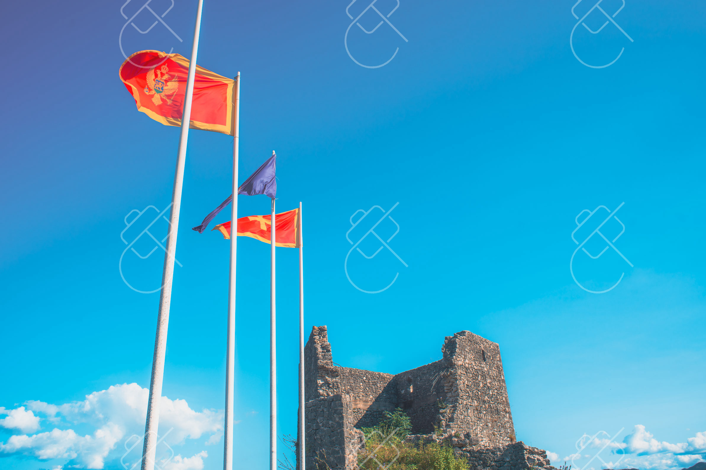 Flags flying over the ruined ramparts of Bedem — Bedem Fortress, fine art travel photography print available from Clever Tourists