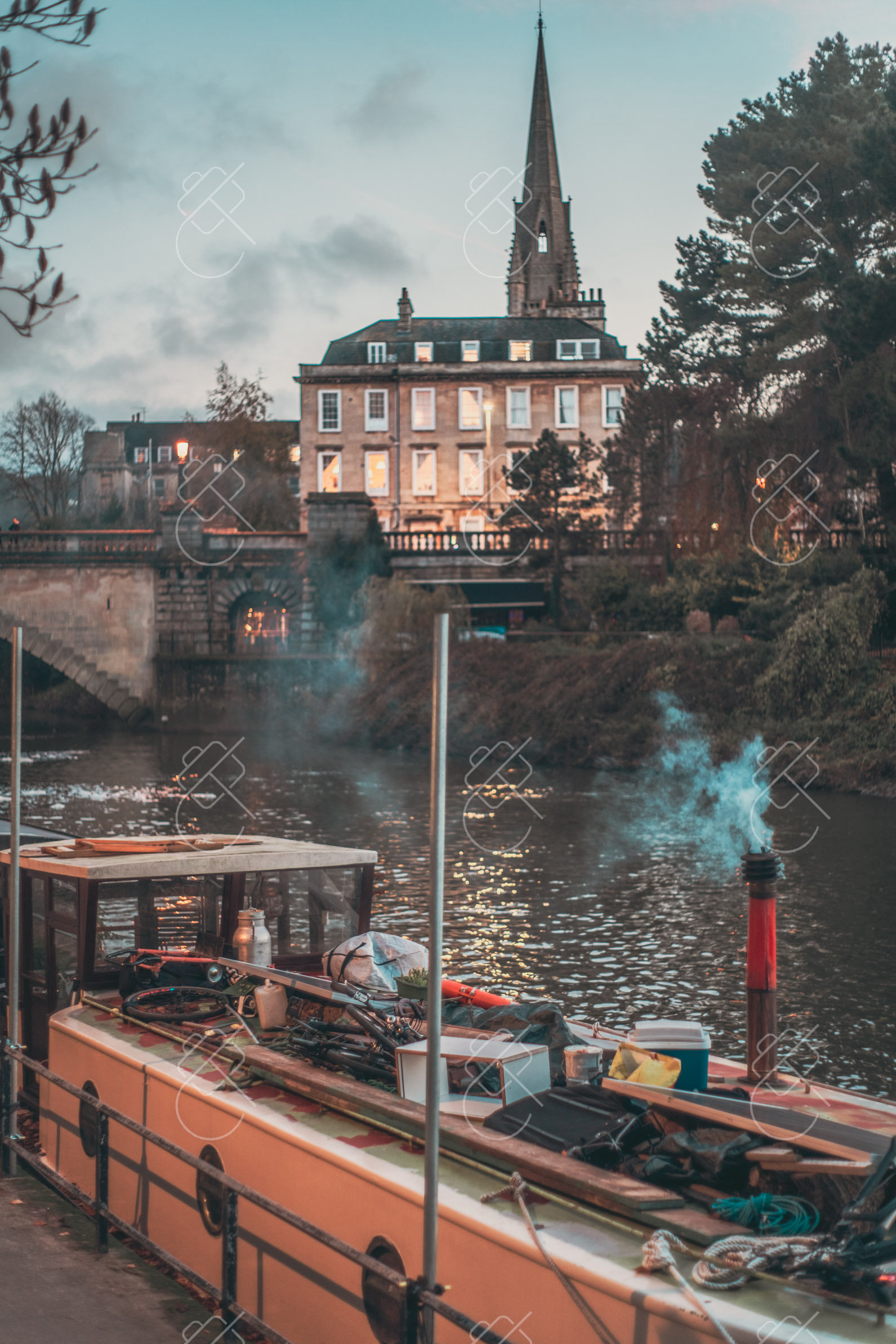 A narrowboat moored on the River Avon, chimney smoke drifting past lit Georgian windows — Bath, fine art travel photography print available from Clever Tourists